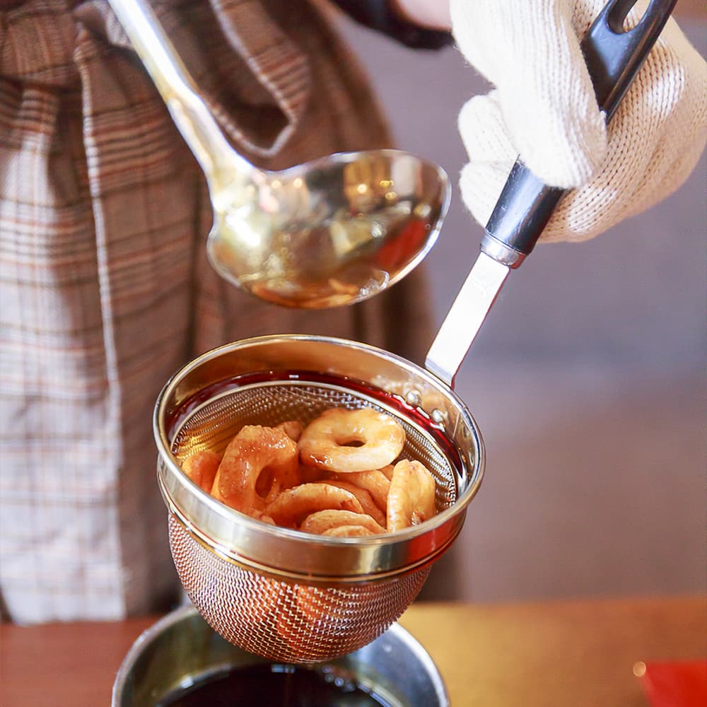 こんがり焼きあがったあられに秘伝醤油をつける